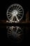 Observation wheel in Gdansk, Poland at night. Pleasure attraction with illumination and reflection in dark water