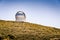 Observatory on a mountain. Large telescope dome. Gran Telescopio Canarias. Dark sky site in the mountains of La Palma. Blue sky.