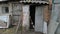 Obsolete abandoned brick shed with a damaged and weathered structure and broken door on an old farm or rural backyard