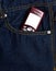 Obsolete button phone with a screen for copy space in the front pocket of jeans