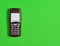 Obsolete button phone with a screen for copy space on a green background. Minimalist trend