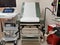 Obstetrics table in gynecological clinic with stirrups next to ultrasound machine