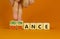 Obstinance or ignorance symbol. Businessman turns cubes, changes the word ignorance to obstinance. Beautiful orange table, orange