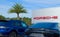 OCALA, FLORIDA USA - OCTOBER 22, 2023 Porsche dealership with red logo on front of building and back end of black Panamera 4.