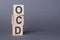 OCD - Obsessive Compulsive Disorder, text, written on wooden blocks, on gray background