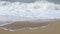 Ocean background live wallpaper. Stormy dark water white sea foam empty sand beach crashing waves