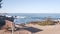 Ocean beach and sea waves, California coast. Beachfront waterfront empty bench.