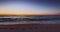 Ocean beach sunrise and footprints on the sea sand shore