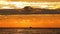 Ocean beach sunrise with golden sky clouds, sun rays and sailing boat and ship in ripple water