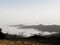 An ocean of clouds between the mountains and a small chair and some firewood to sit and watch for hours