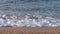 Ocean coast. Sandy beach, blue waves with sea foam. 4K Slow Mo