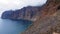 Ocean deep blue waves crash into the black volcanic shore of Tenerife. Cinematic shot of turquoise water swell violently