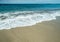 Ocean foam covering beautiful long sandy beach