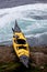 Ocean kayak beached on rocky shore at tidal rapids