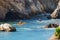 Ocean kayaking. Group of people paddling kayaks overlooking Pacific ocean, rocky cliffs and caves close to Shell Beach, California