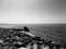 The ocean and rocky shore in black and white