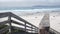 Ocean sandy beach, California coast, sea water wave crashing. Stairs or stairway