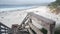 Ocean sandy beach, California coast, sea water wave crashing. Stairs or stairway