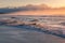 Ocean sandy beach with mild waves at sunrise