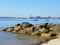 Ocean shoreline, boulder pier, boats and sea kayakers in backgro