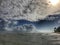 The ocean sunset. The setting sun highlights some cumulus clouds with golden rays