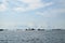 Ocean transport shipping vessels anchored far from the shore under cloudy skies