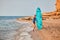 Ocean view and sandy beach. Lady in swimsuit with surfboard. Surf hobby, summer vacation and adventure idea. Copy space
