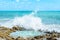 Ocean water splashing on rocks and forming a natural pool in the center of the image