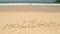 Ocean wave approaching word holidays written in sand on beach