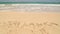 Ocean wave approaching words Sri Lanka written in sand on beach