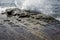 Ocean wave breaking over fractured rocks in Tasmania