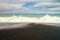 Ocean wave contrasting with black stones beach Whirinaki beach near Napier, New Zealand