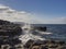 Ocean wave crushes on rock coast of West coast of Ireland Cloudy sky, Warm sunny day. Nobody