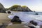 Ocean wave and rock cliffs on sandy beach, Portugal