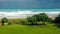 Ocean wave rolling towards sandy beach with green trees of Taiwan island