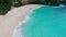 Ocean wave on tropical beach. White sand and crystal-blue sea. Aerial view