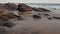 Ocean wave washing the coastal boulders and rocks