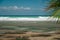 Ocean waves breaks against coral reef during sea water low tide times. Turquoise tropical seascape with blue skies