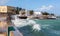 Ocean waves crash over a seawall to seafront embankment. Mozambique island, Indian ocean coast. Portuguese East Africa.