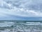 Ocean waves lapping on the beach  on a beautiful cloudy day along the shoreline