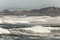 Ocean waves and rocky hillside shore