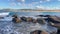 Ocean waves roll into the rocks and sandy beach