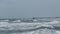 Ocean waves in rough seas and long walking pier.