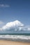 Ocean waves with sandy beach and cumulus cloud