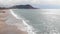 Ocean waves with white foam at stormy windy day. Sea waves are splashing and crashing on sandy beach. Beautiful sea landscape