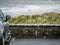 Ocean weaves in focus, Small black car out of focus in foreground. Rosses point, county Sligo, Ireland. Concept travel