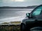 Ocean weaves in focus, Small black car out of focus in foreground. Rosses point, county Sligo, Ireland. Concept travel