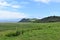 Oceanside landscape with a green rolling hill ranch along the road to Hana on the island of Maui