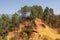 Ochre Trail in Roussillon, Hiking path in orange ocher cliffs surrounded by green forest in Provence, Southern France