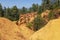 Ochre Trail in Roussillon, Hiking path in orange ocher cliffs surrounded by green forest in Provence, Southern France